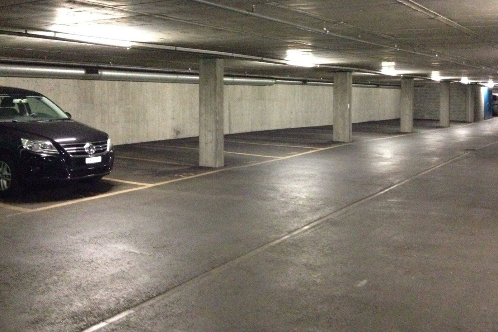 Parkebene der Tiefgarage Kornquader mit markierten Stellplätzen entlang der Betonwand